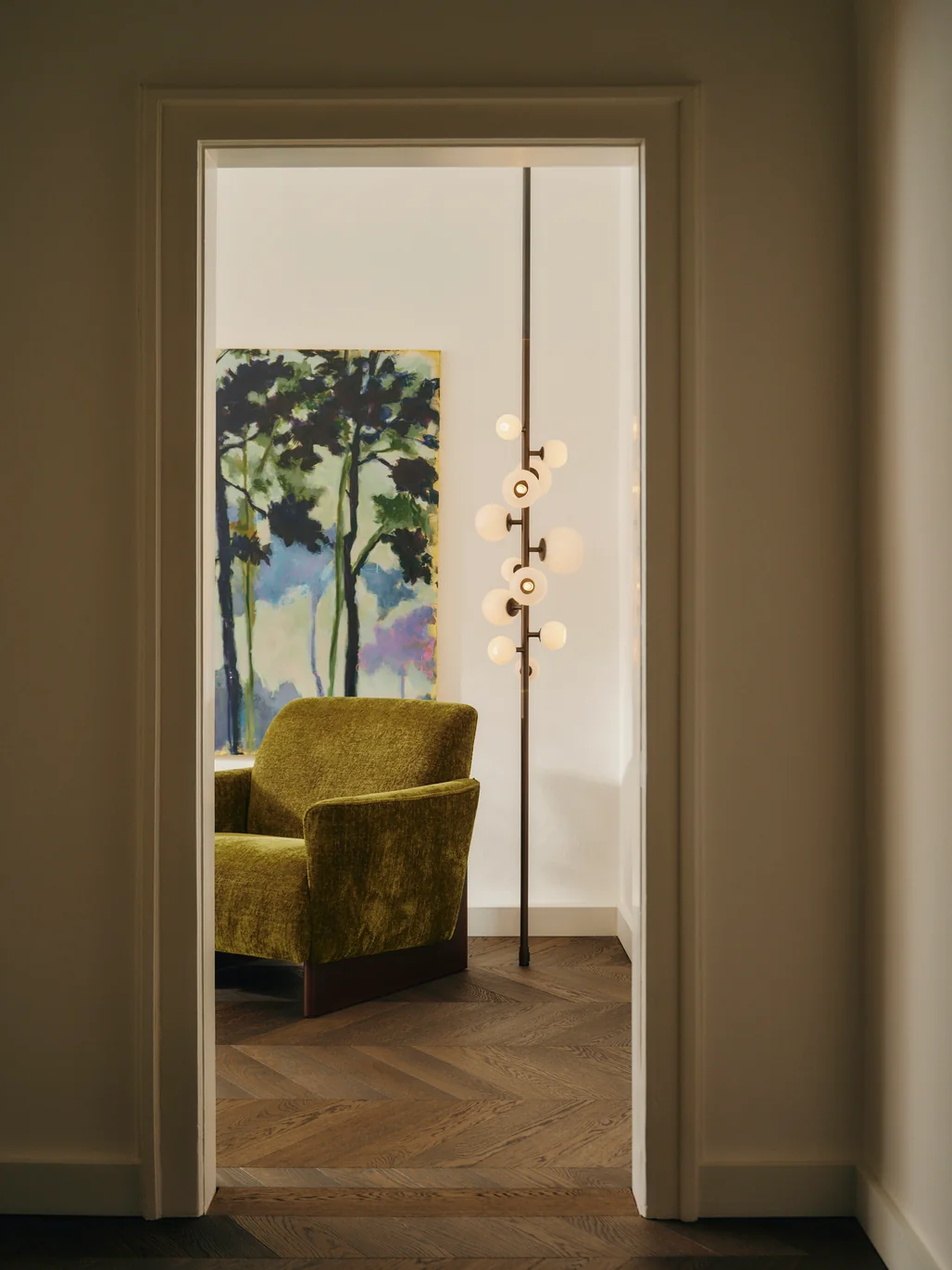 View through a doorway onto a green velvet armchair. Photo: Conny Mirbach