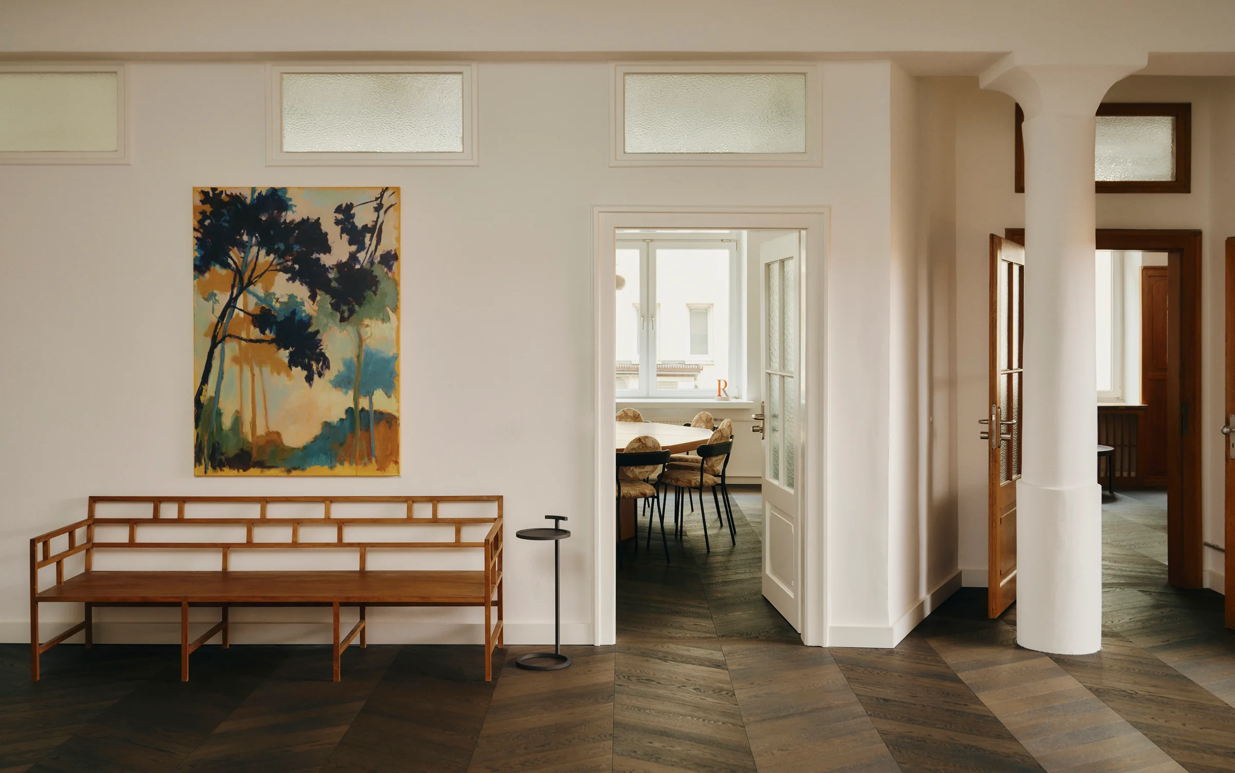 Showroom at Le Comptoir with a wooden bench, a landscape painting and a view into the next room. Photo: Conny Mirbach