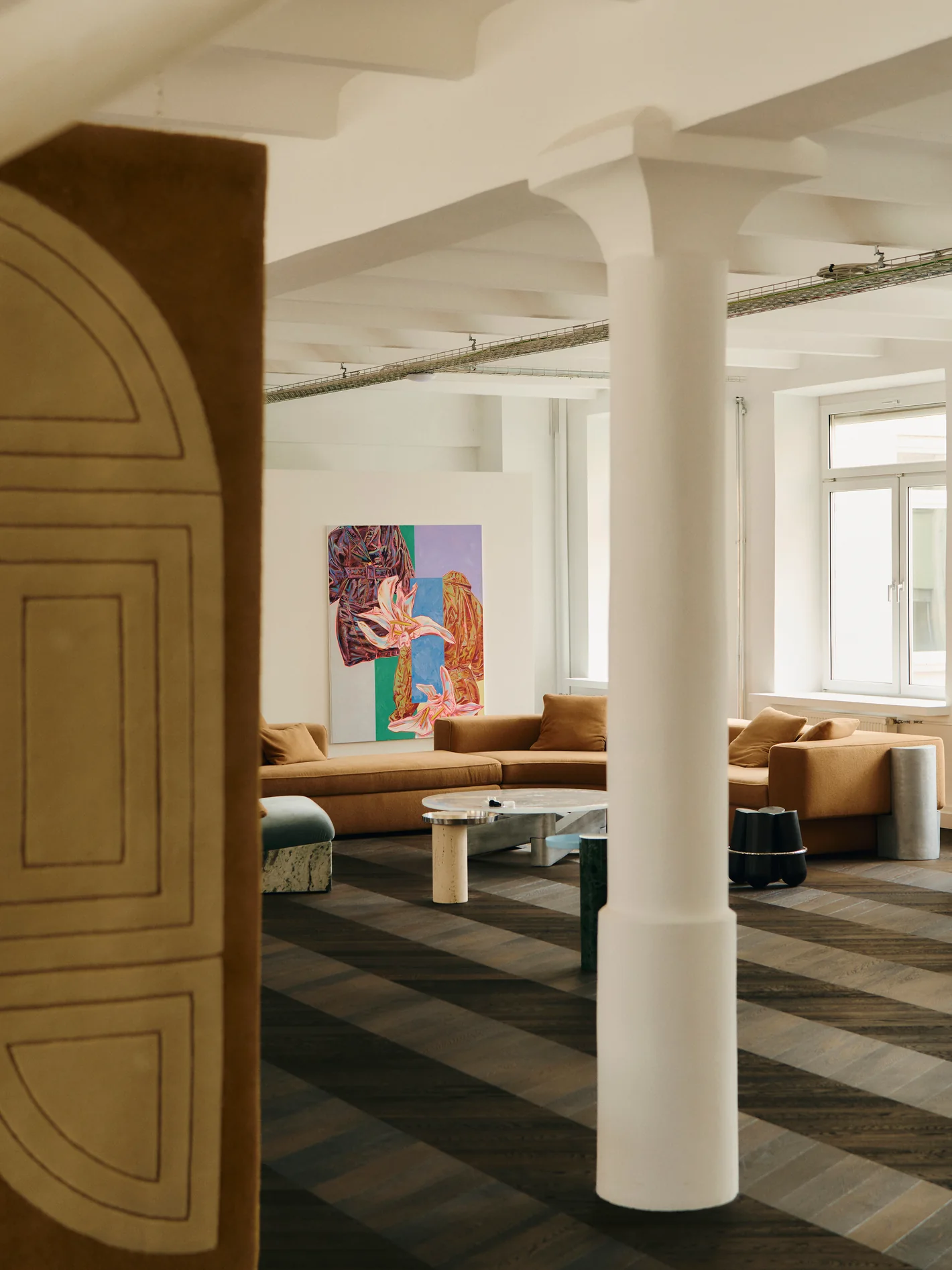 View past a carved wooden door into the lounge with its white columns and colourful paintings. Photo: Conny Mirbach