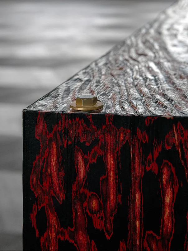 Detail of a lacquered wooden cube with a hammered metal top